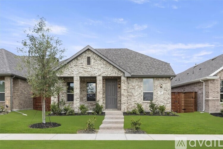 A house with a grey front door and a tree in front.