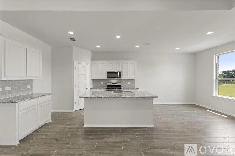 A modern kitchen with white cabinets and a central island.