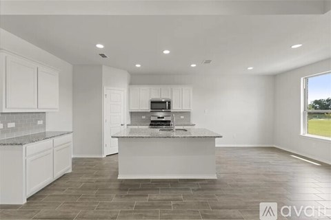 A modern kitchen with white cabinets and a central island.