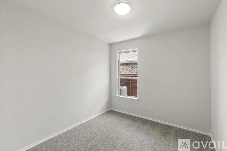 A room with a window and a view of a building outside.