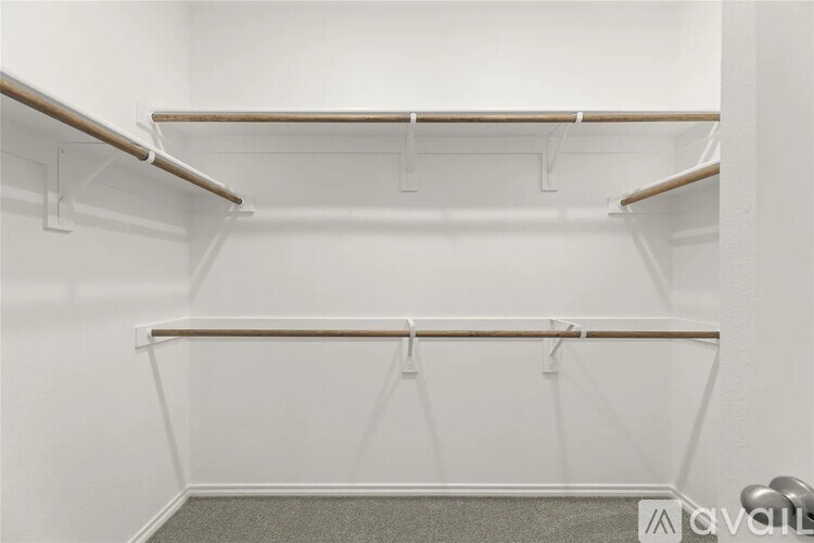 A white closet with shelves and hooks.