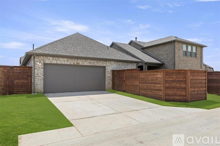 A house with a grey garage door and a wooden fence.