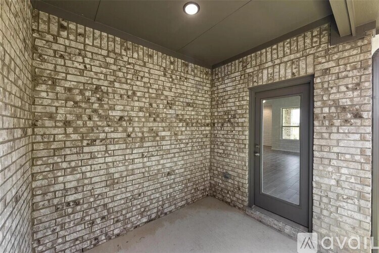 A room with a brick wall and a glass door.