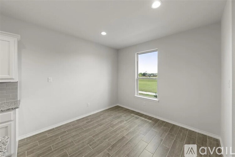 A room with a window showing a green field outside.