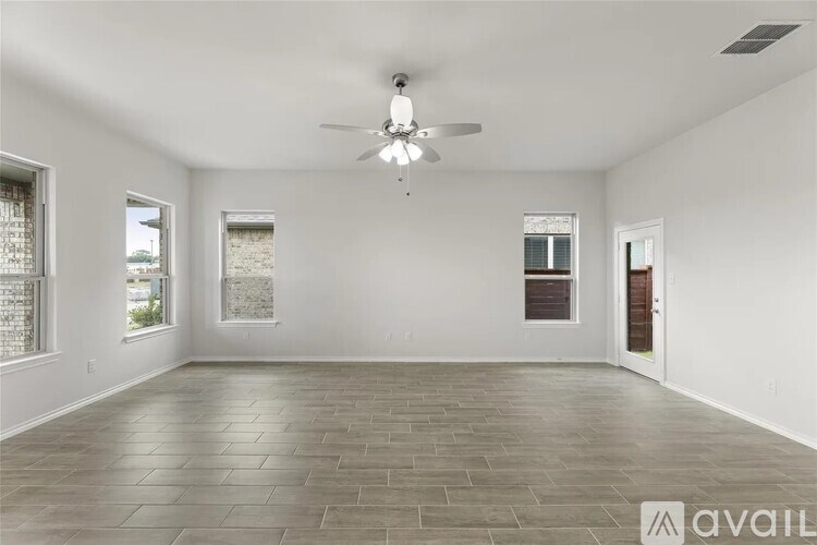 A spacious room with a ceiling fan and tiled flooring.
