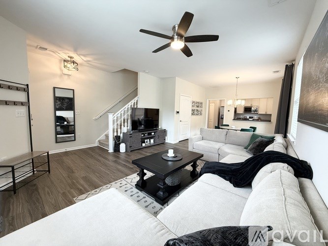 A living room with a white couch and a black coffee table.