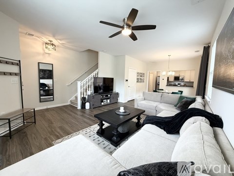 A living room with a white couch and a black coffee table.