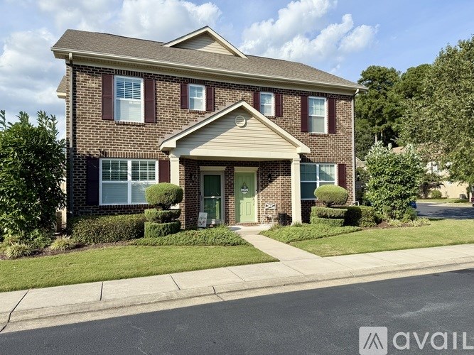 A brick house with a green lawn in front.