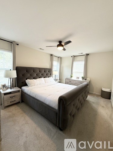 A bedroom with a large bed and a ceiling fan.