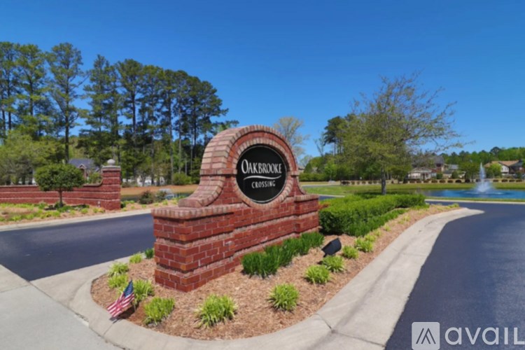 A sign that says Oakbrook Estates in front of a road.