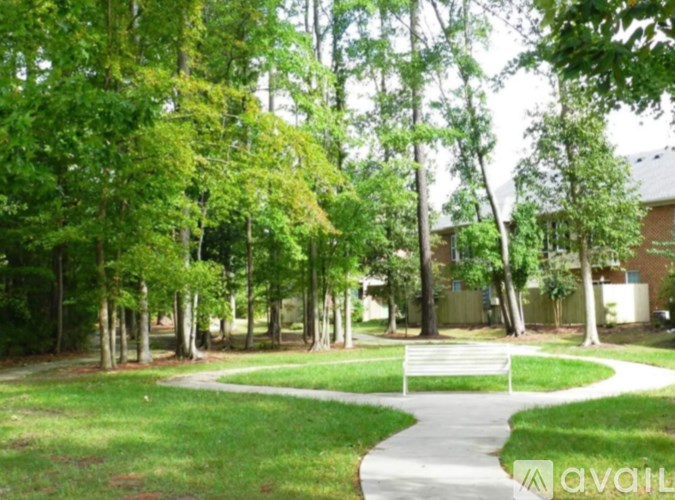 A park with a walking path and trees.