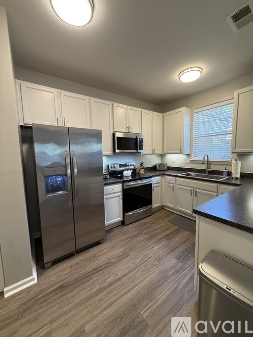 A kitchen with a refrigerator, microwave, oven, and dishwasher.