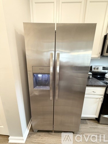 A stainless steel refrigerator with its door open in a kitchen.