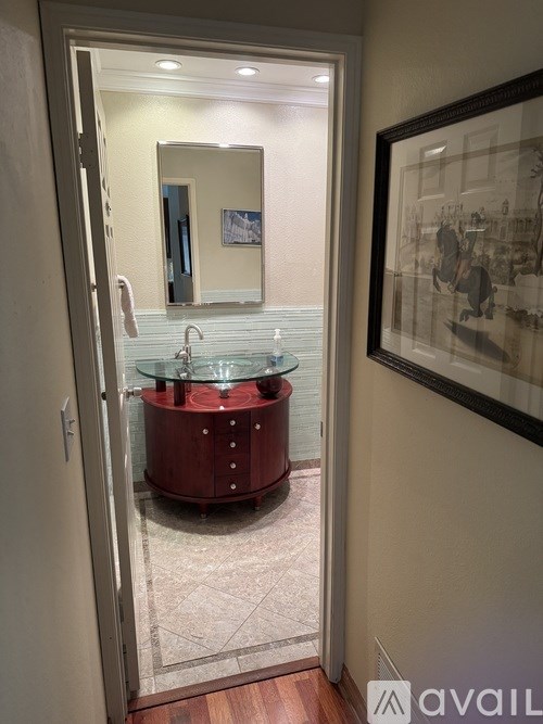 A bathroom with a red tub and a mirror above it.