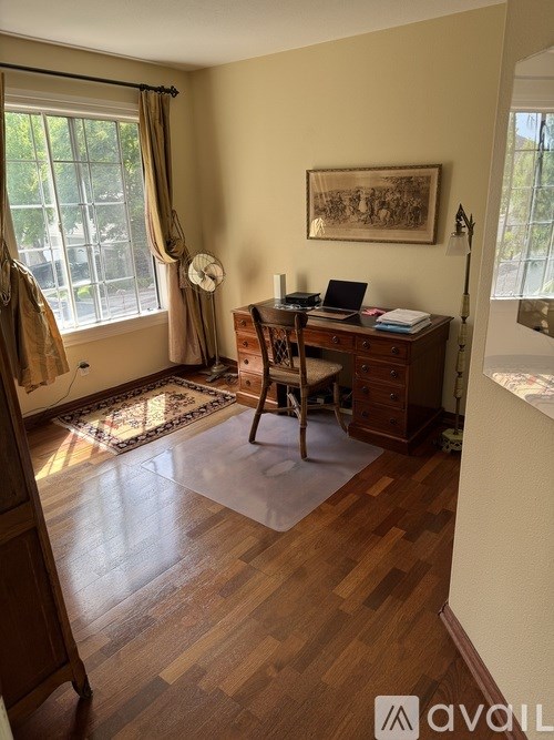 A room with a desk and a chair in front of a window.
