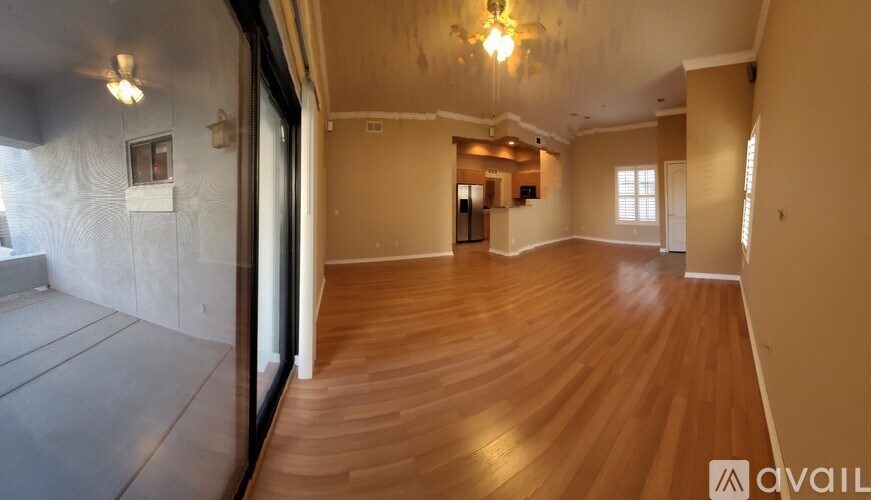 A spacious room with wooden flooring and a chandelier.