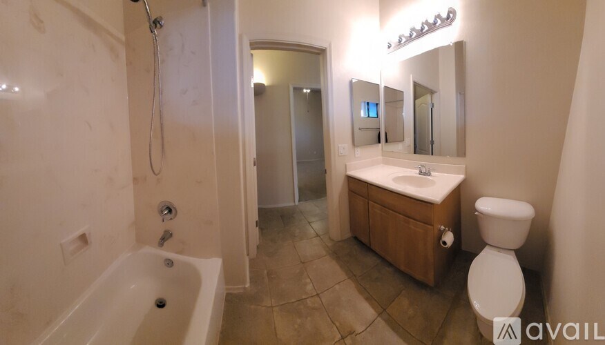 A bathroom with a white tub, sink, and toilet.