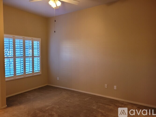 A room with a window and a carpeted floor.