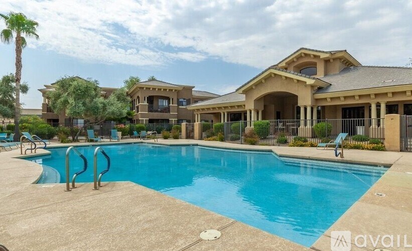 A large swimming pool in front of a building with a palm tree.