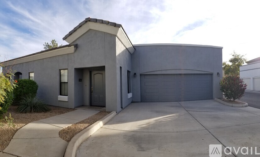 A modern house with a grey exterior and a large driveway.