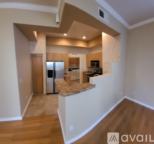 A kitchen with a refrigerator, microwave, and oven is available for rent.