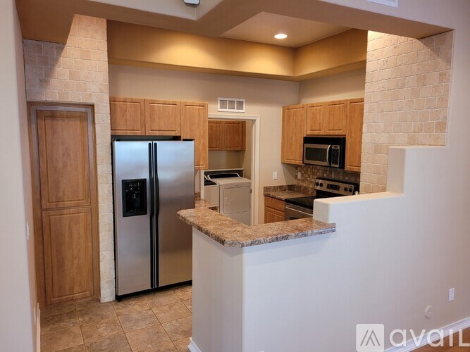 A kitchen with a refrigerator, microwave, and oven.