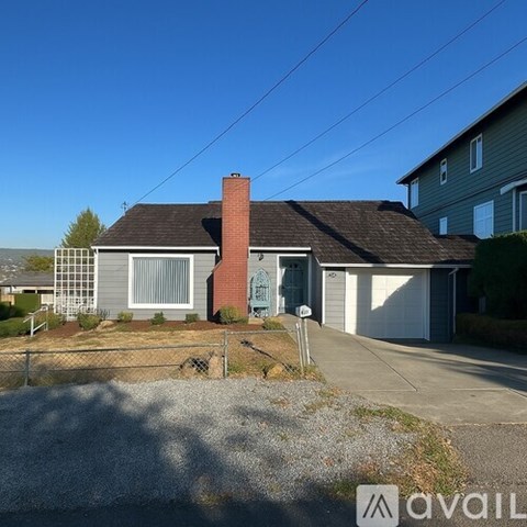 A house with a grey front yard and a fence.