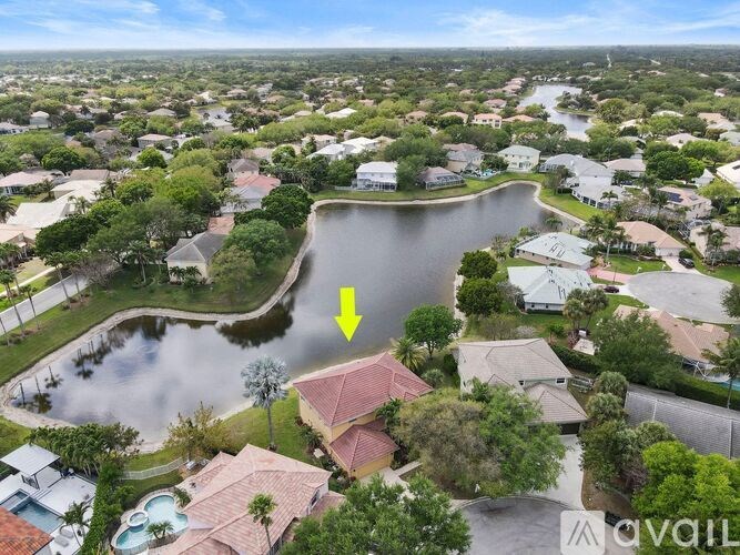 A bird's eye view of a residential area with a lake and a house with a red roof.