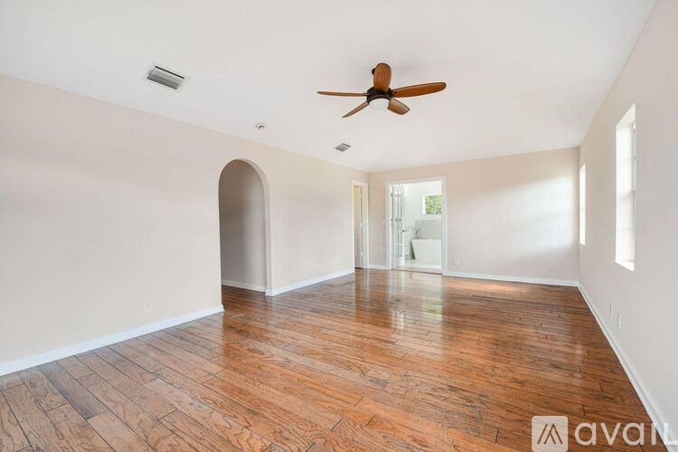 A room with wooden floors and a ceiling fan.