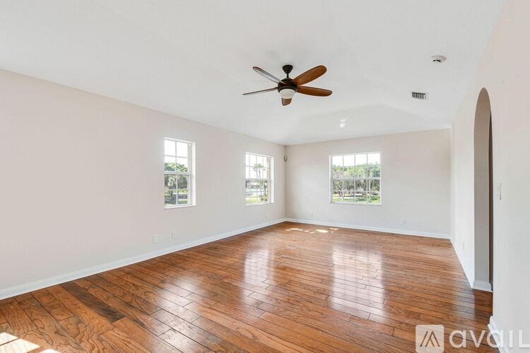 A room with wooden floors and a ceiling fan.