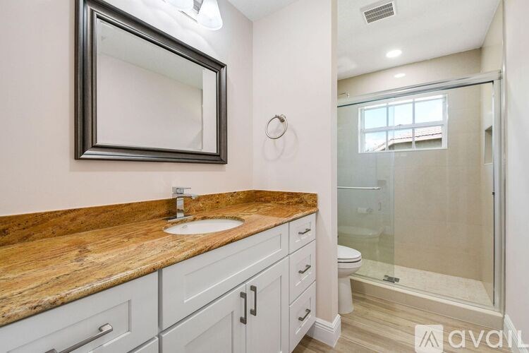 A bathroom with a wooden countertop and a large mirror above it.