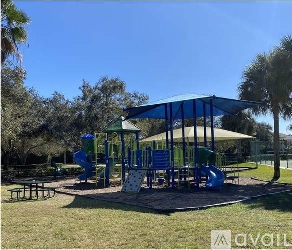 A playground with a blue slide and a green canopy.