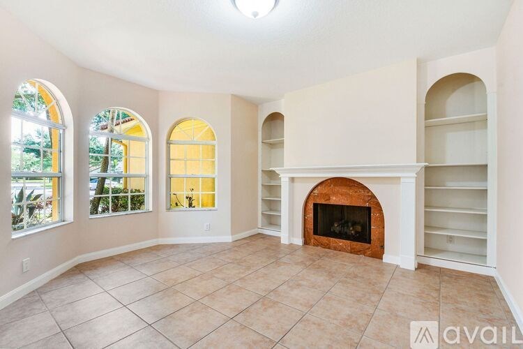 A living room with a fireplace and arched windows.