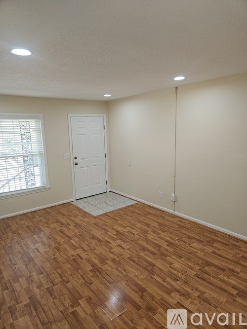 A room with wooden flooring and a white door.