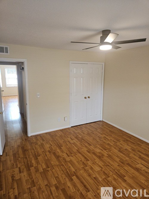 A room with a white door and a ceiling fan.
