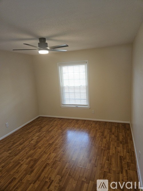 A room with wooden flooring and a ceiling fan.