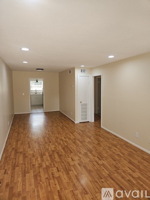 A room with wooden flooring and white walls.