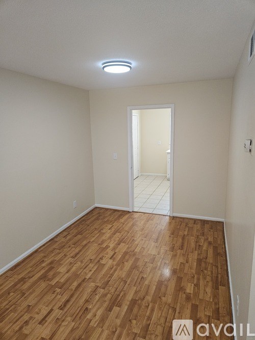 A room with wooden flooring and a white door.