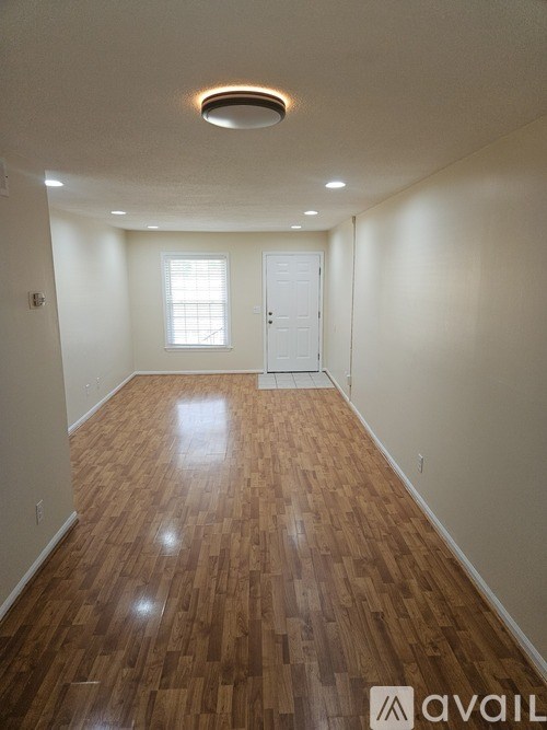 A room with wooden flooring and a white door.