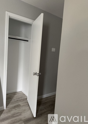 A white door is open to a room with a grey wall.