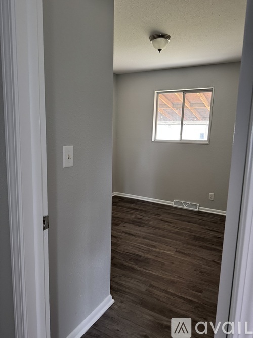 A room with a window and wooden flooring.