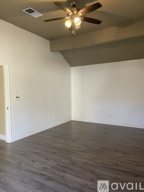 A room with a ceiling fan and light fixture.