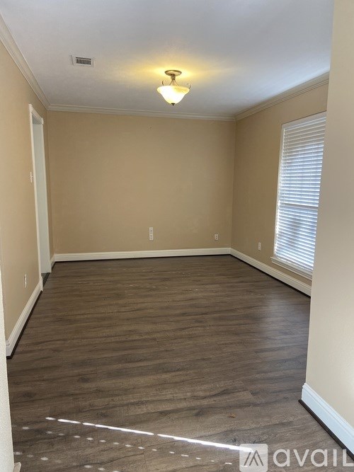 A room with wooden flooring and a light on the ceiling.
