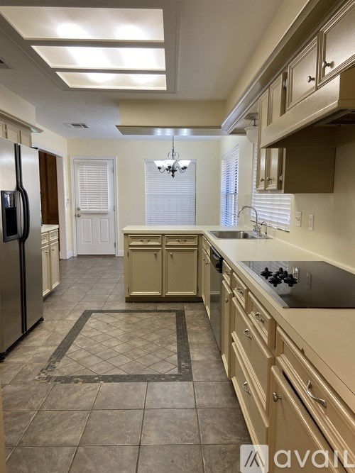 A kitchen with a refrigerator, cabinets, and a countertop.