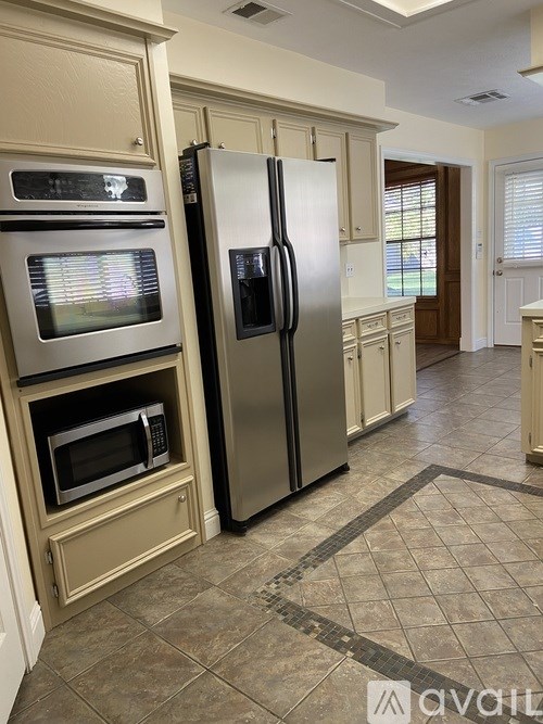 A kitchen with a stainless steel refrigerator and a microwave oven.