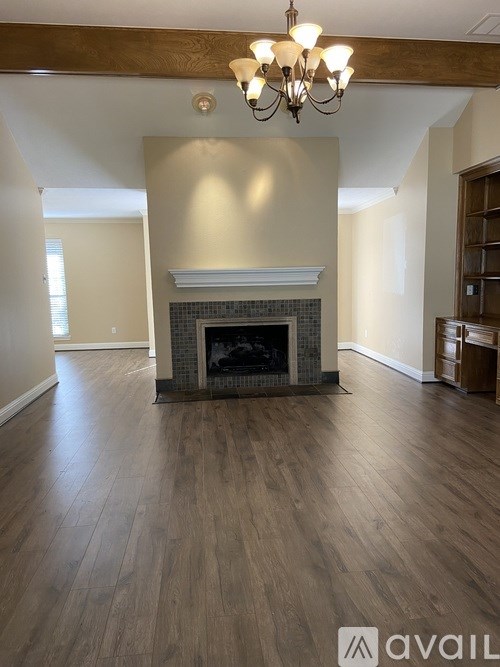 A living room with a fireplace and wood flooring.