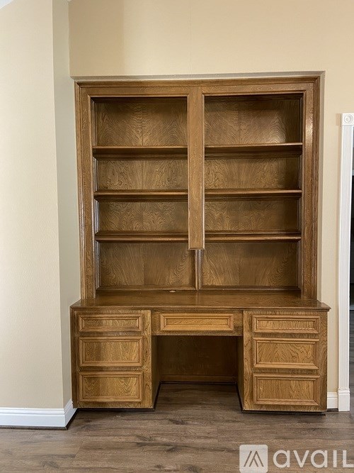 A wooden desk with drawers and shelves in a room.