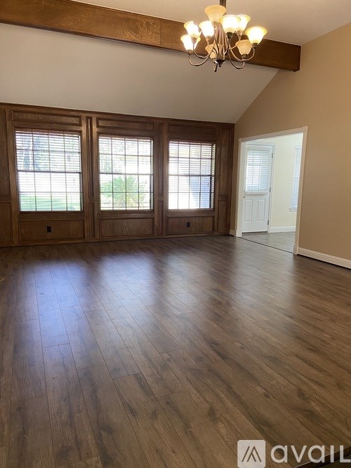 A room with wooden floors and a chandelier.