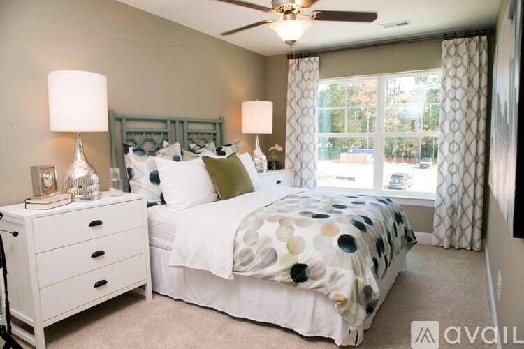 A bedroom with a bed, nightstand, and window.