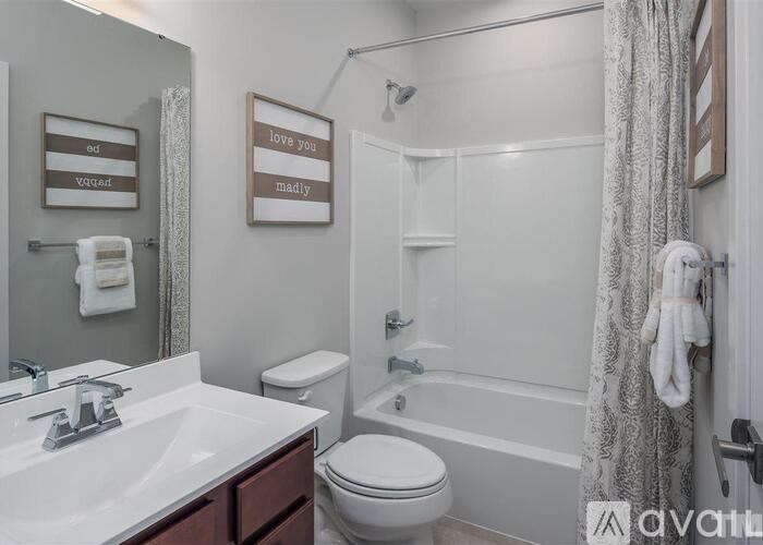 A bathroom with a toilet, sink, and bathtub.